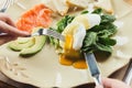 Woman having healthy breakfast with poached eggs and smoked salm Royalty Free Stock Photo