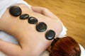 Woman having hot stones on her back in spa salon for relaxation Royalty Free Stock Photo