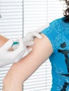 Woman having an injection on arm at hospital injecting vaccine vaccination medicine flu by doctor Royalty Free Stock Photo