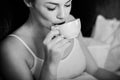 Woman having morning coffee in bed, black and white Royalty Free Stock Photo