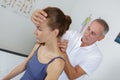 Woman having neck massaged by physiotherapist