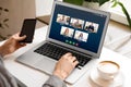 Woman having online meeting with her team via laptop