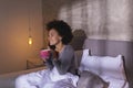Woman having a phone conversation and drinking coffee in bed Royalty Free Stock Photo
