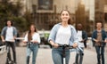 Woman having ride on motorized kick scooter with friends Royalty Free Stock Photo