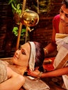Woman having Shirodhara pouring oil on head in India spa .