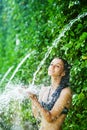 Woman having shower under tropical waterfall Royalty Free Stock Photo