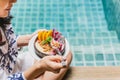 Woman having smoothie breakfast by swimming poo. Royalty Free Stock Photo