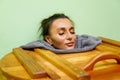 Woman having spa treatment in wooden barrel sauna, cedar bathtub