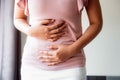 Woman is Having Stomach Ache or Menstrual Period, Close-Up Portrait of Young Woman is Suffering From Abdominal Pain at Her Home. Royalty Free Stock Photo