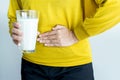 Woman having a stomach pain and hands holding a glass of milk,Allergy dairy intolerant,Lactose intolerance concept