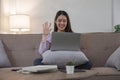 Woman having video call on her laptop at home. Smiling girl smile to family or friends Royalty Free Stock Photo