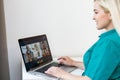 Woman having video chat with colleagues at table in office, closeup