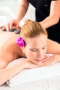 Woman having wellness spa hot stone massage Royalty Free Stock Photo