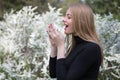 Woman with hay fever in front of white flowers