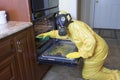 Woman in Haz Mat suit cleaning oven Royalty Free Stock Photo