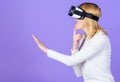 Woman head mounted display violet background. Virtual reality and future technology. Girl use modern technology vr