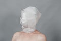 Woman head wrapped in white tissue paper. A symbol of loneliness and alienation