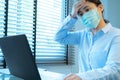 Woman headache with face mask protection while working, Coronavirus, air pollution, allergic sick woman with medical mask