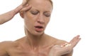 Woman with headache holding pills in the hand