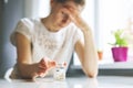 Woman with headache reaching for painkiller pills. migraine, cephalalgia and stress concept Royalty Free Stock Photo