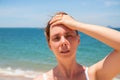 Woman with headache on sunny beach. Young woman having sunstroke. Health problem on vacation. Medicine on vacation