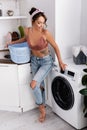 Woman in headband touching washing machine