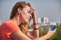 Woman with headphones on, listening to a song on her phone and looking sad with her eyes closed Royalty Free Stock Photo