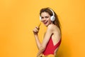 Woman in headphones listens to music emotions lifestyle fun yellow background
