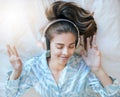 Woman, headphones and music, listening in bed to relax at home, podcast or radio streaming, peace and satisfaction