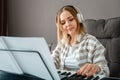 Woman in headphones playing piano music on synthesizer from notes. Teenager girl musician pianist improves skills Royalty Free Stock Photo