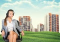 Woman in headphones sits on chair. Buildings Royalty Free Stock Photo