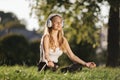 Woman in headphones sitting in lotus pose on grass Royalty Free Stock Photo