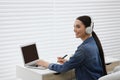 Woman in headphones studying on laptop indoors. Online translation course