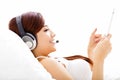 Woman with headphones and tablet on the bed Royalty Free Stock Photo