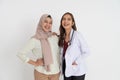 woman in headscarf and beautiful female doctor laughing together looking at camera embracing pose Royalty Free Stock Photo