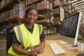 Woman with headset in a warehouse office looks to camera Royalty Free Stock Photo