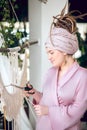 Woman in a headwear cutting yarn while weaving macrame