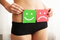 Woman Health Problem. Closeup Of Female With Fit Slim Body In Panties Holding Two Card With Sad Smiley And Happy Face Royalty Free Stock Photo