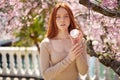 woman with healthy smooth clean skin holding cream bottle for body, in garden Royalty Free Stock Photo