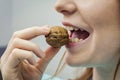 Woman with healthy tooth cracking walnut