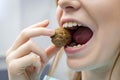 Woman with healthy tooth cracking walnut