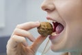 Woman with healthy tooth cracking walnut