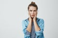 Woman heard horrible news and worries. Studio shot of young good-looking female student with troubled expression holding