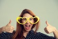 Woman with heart shaped party glasses happy  showing thumbs up hands gesture Royalty Free Stock Photo