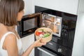 Woman heating food with microwave machine Royalty Free Stock Photo