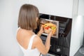 Woman heating food with microwave machine Royalty Free Stock Photo