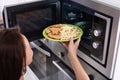 Woman Heating Fried Food In Microwave Oven Royalty Free Stock Photo