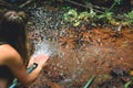 Woman heaving fun with hosepipe splashing water