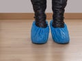 Woman in heels with feet in blue plastic shoe protectors, covers. Hygiene in medical situations etc. Single use