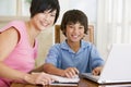 Woman helping boy with laptop doing homework Royalty Free Stock Photo